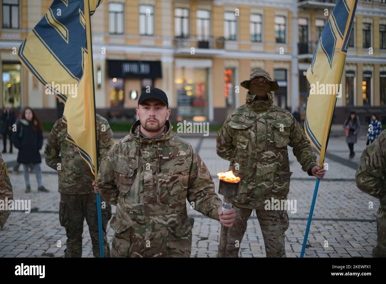 KYIV, UKRAINE - NOVEMBER 13, 2022 - Soldiers of Azov regiment hold flags and burning torches to commemorate their fallen brothers in arms during the Heavenly Regiment of Azov mystery in Sofiyska Square, Kyiv, capital of Ukraine. Stock Photo