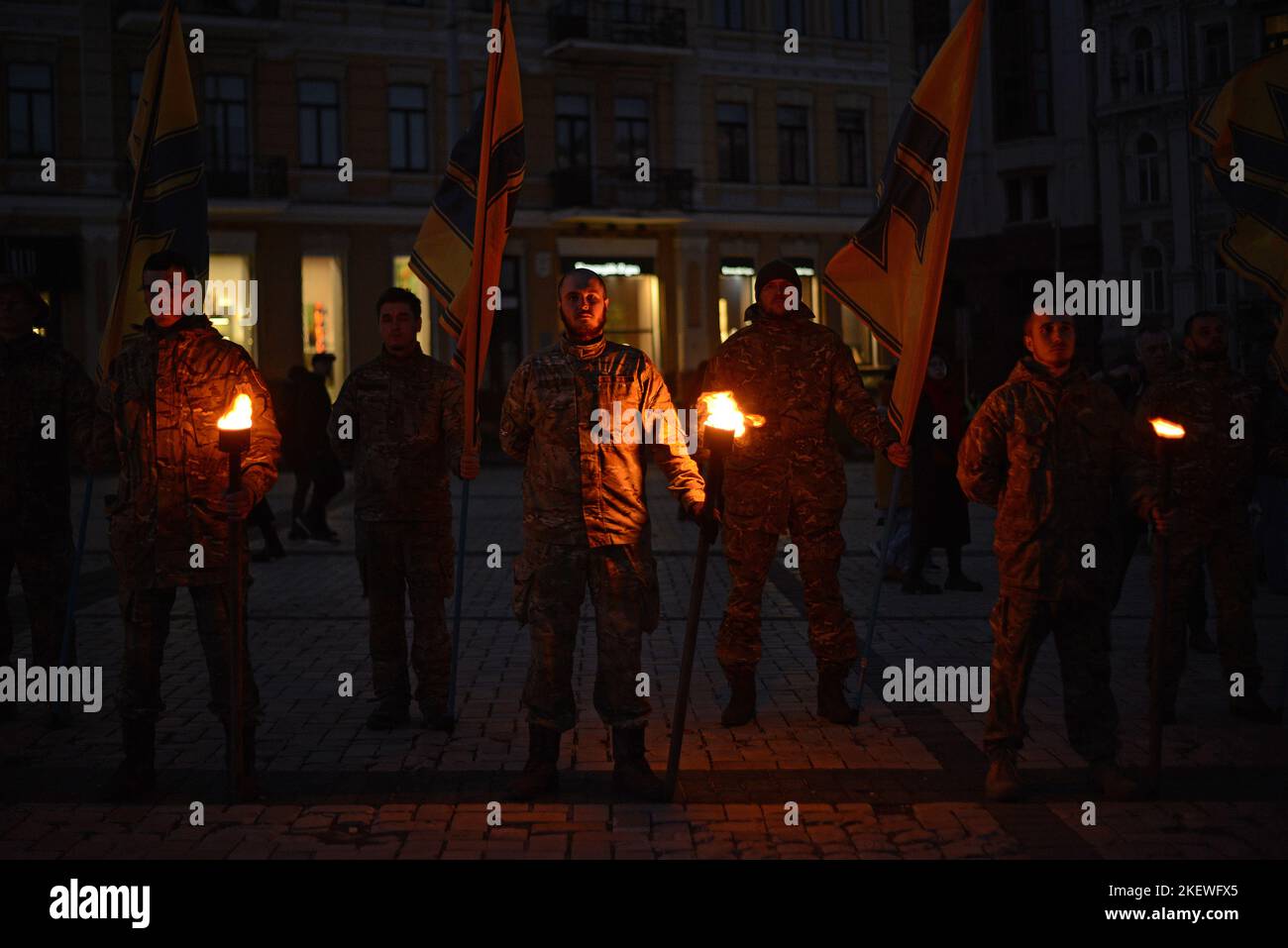 KYIV, UKRAINE - NOVEMBER 13, 2022 - Soldiers of Azov regiment hold flags and burning torches to commemorate their fallen brothers in arms during the Heavenly Regiment of Azov mystery in Sofiyska Square, Kyiv, capital of Ukraine. Stock Photo