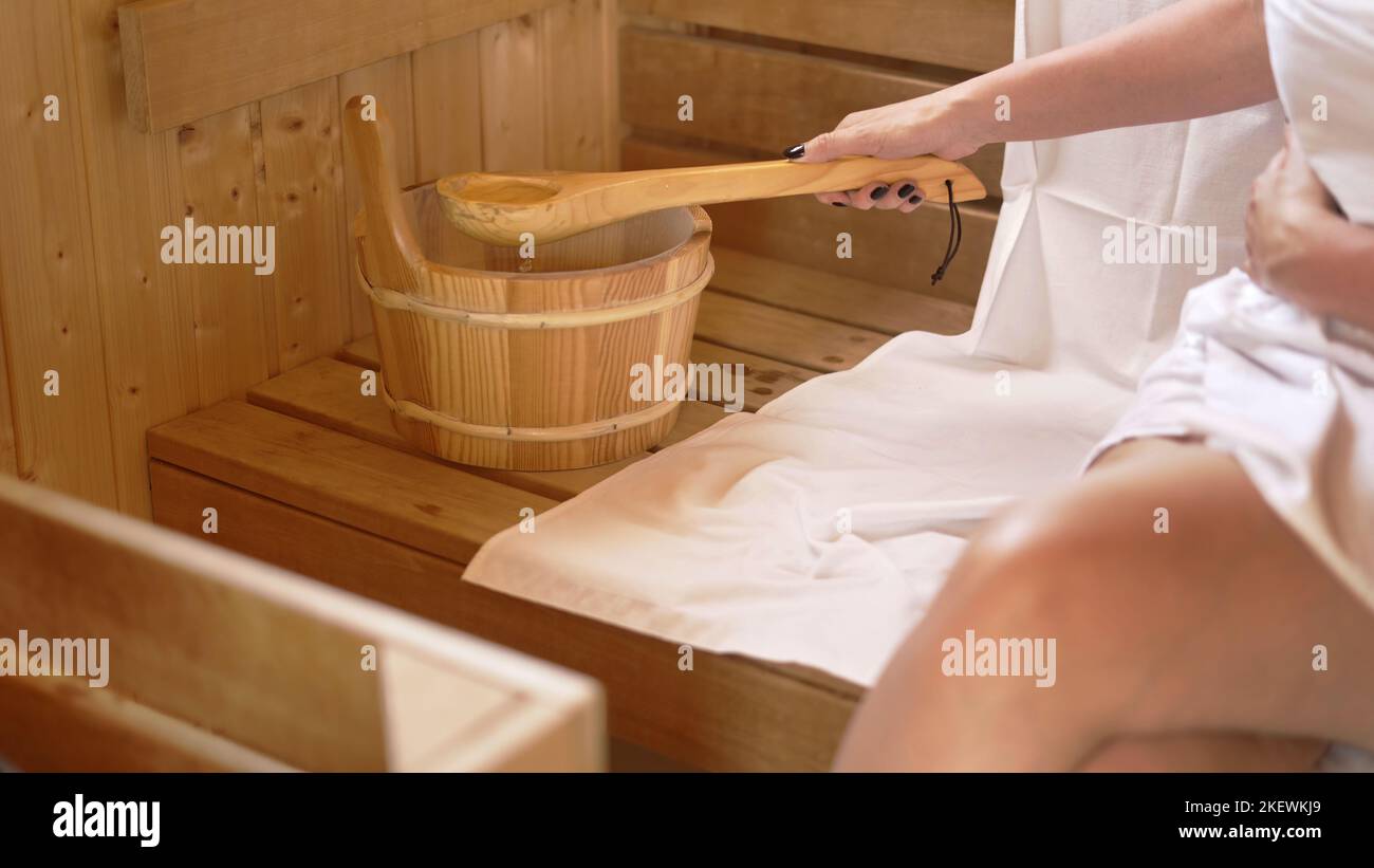 Woman relaxing and sweating in hot sauna. Real, authentic sauna moment