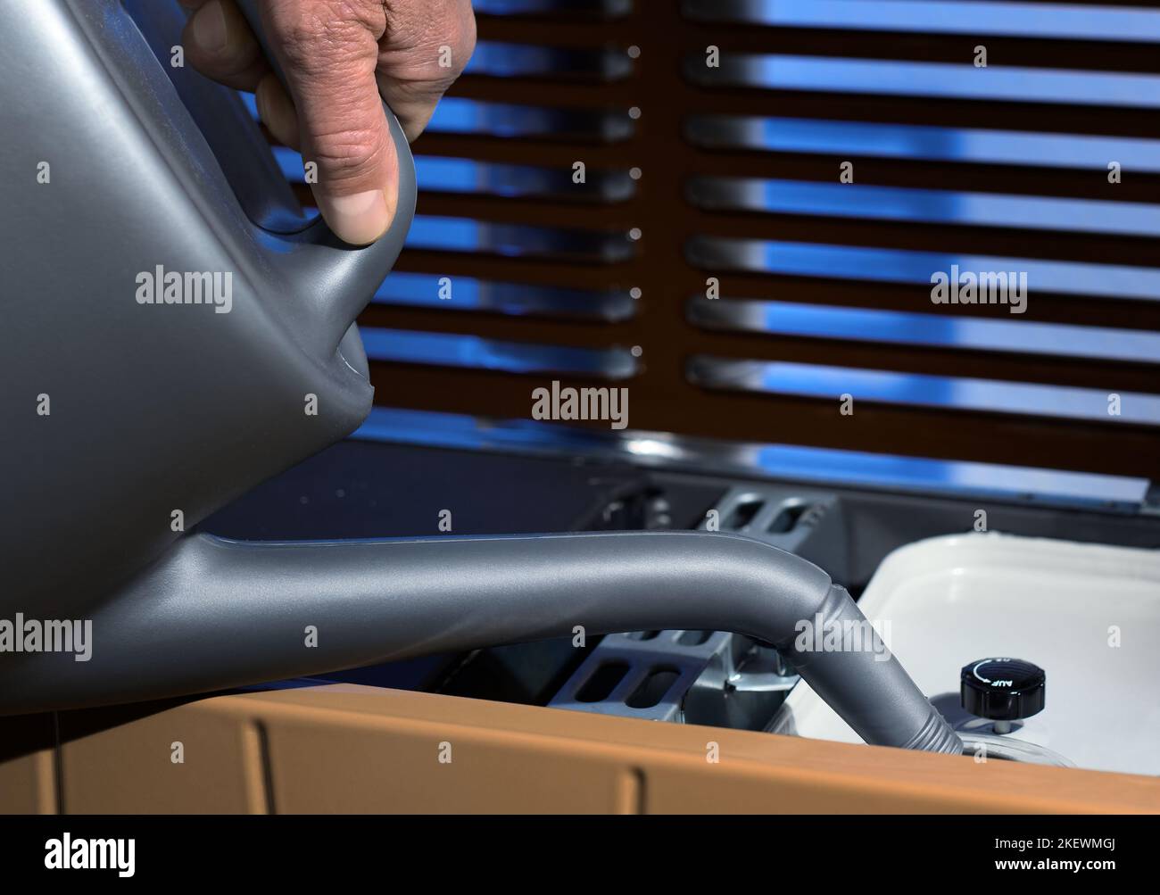 Filling a room stove furnace heater with fuel oil with oilcan can pot