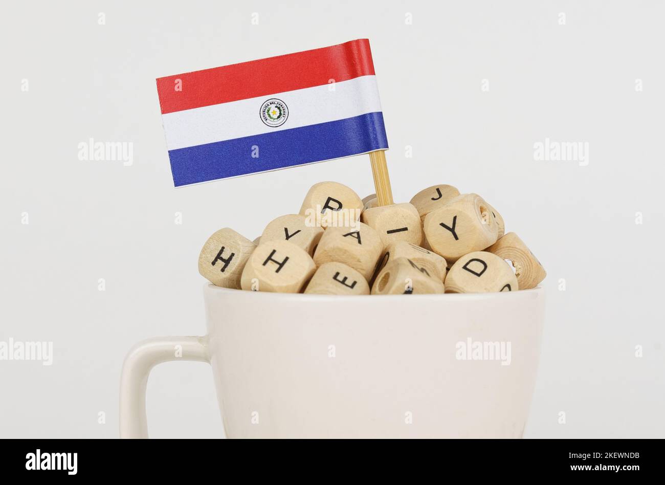 The flag of Paraguay sticks out of a cup with dice on which letters are depicted. Symbol of education. close-up Stock Photo