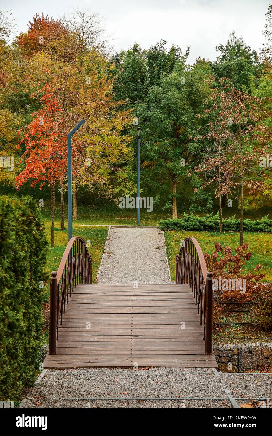 View of autumn park with wooden bridge and trees Stock Photo - Alamy