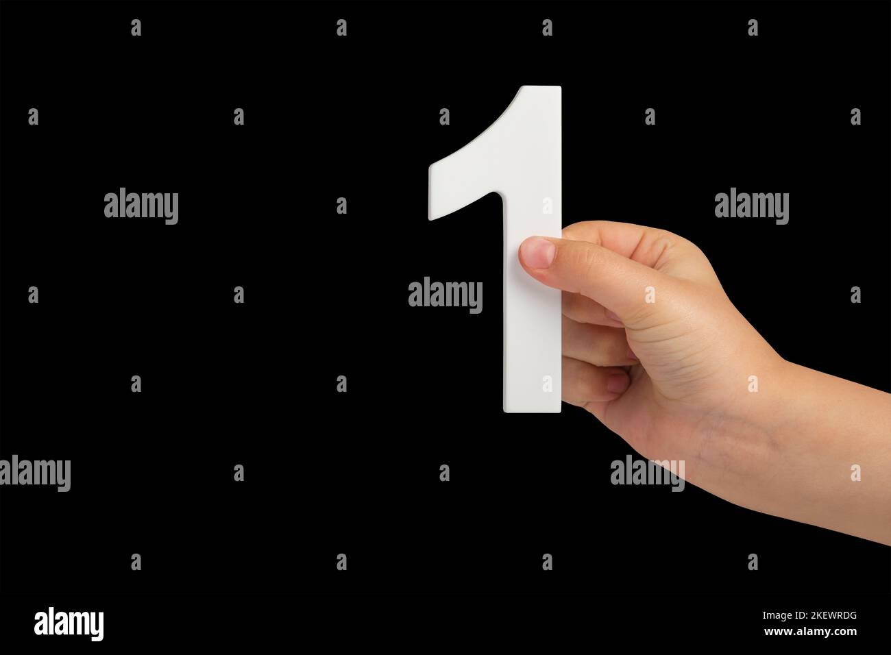 Number one in a hand isolated on a black background. Number one white ...