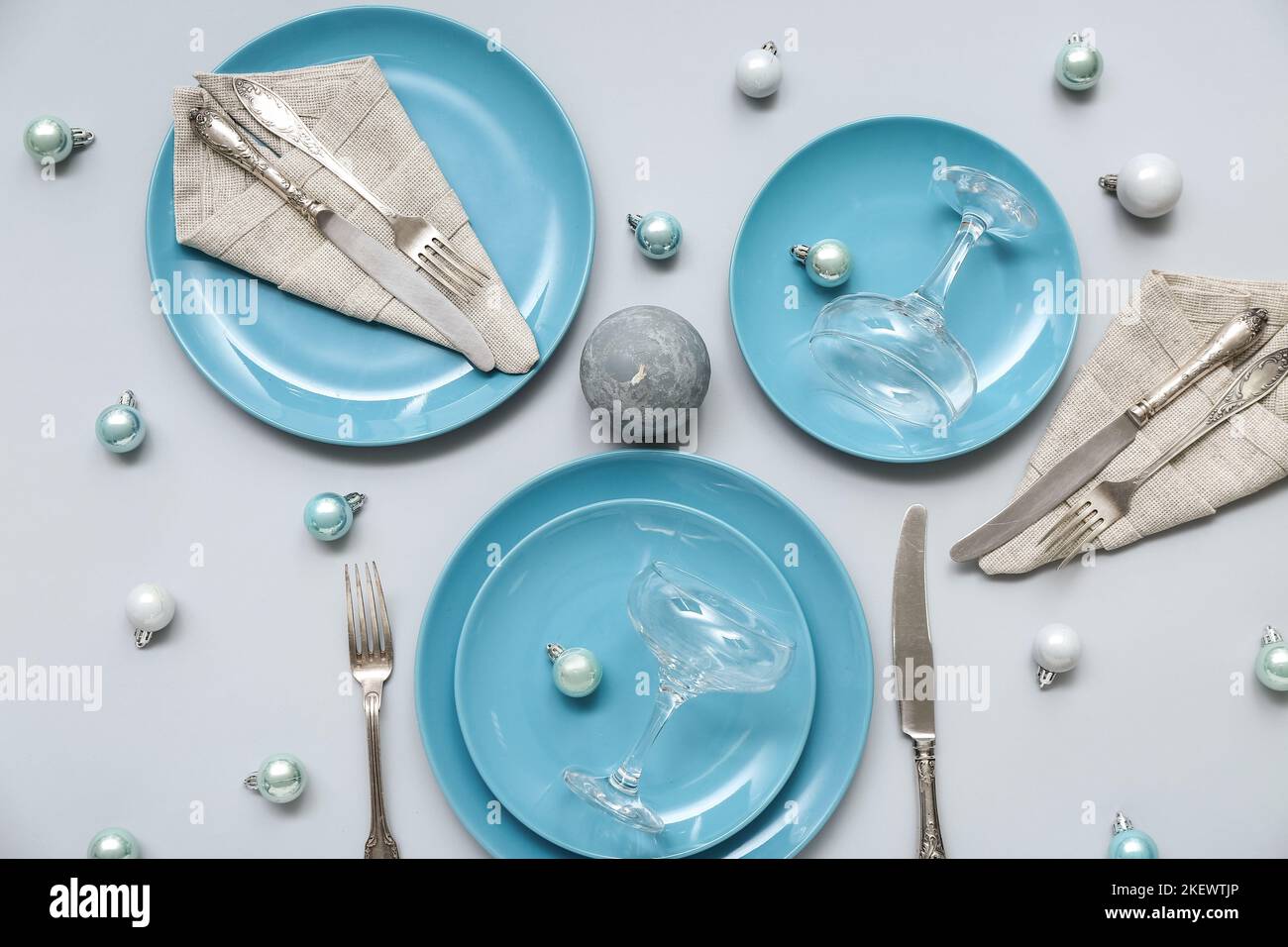 Beautiful table setting with blue plates and Christmas balls on grey ...