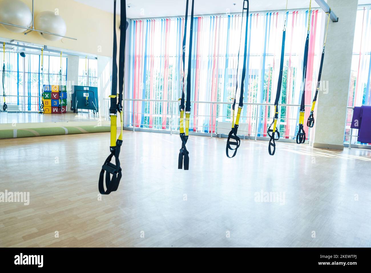 Trx fitness straps for working with own weight. Trx fitness belts hanging in the empty gym Stock Photo