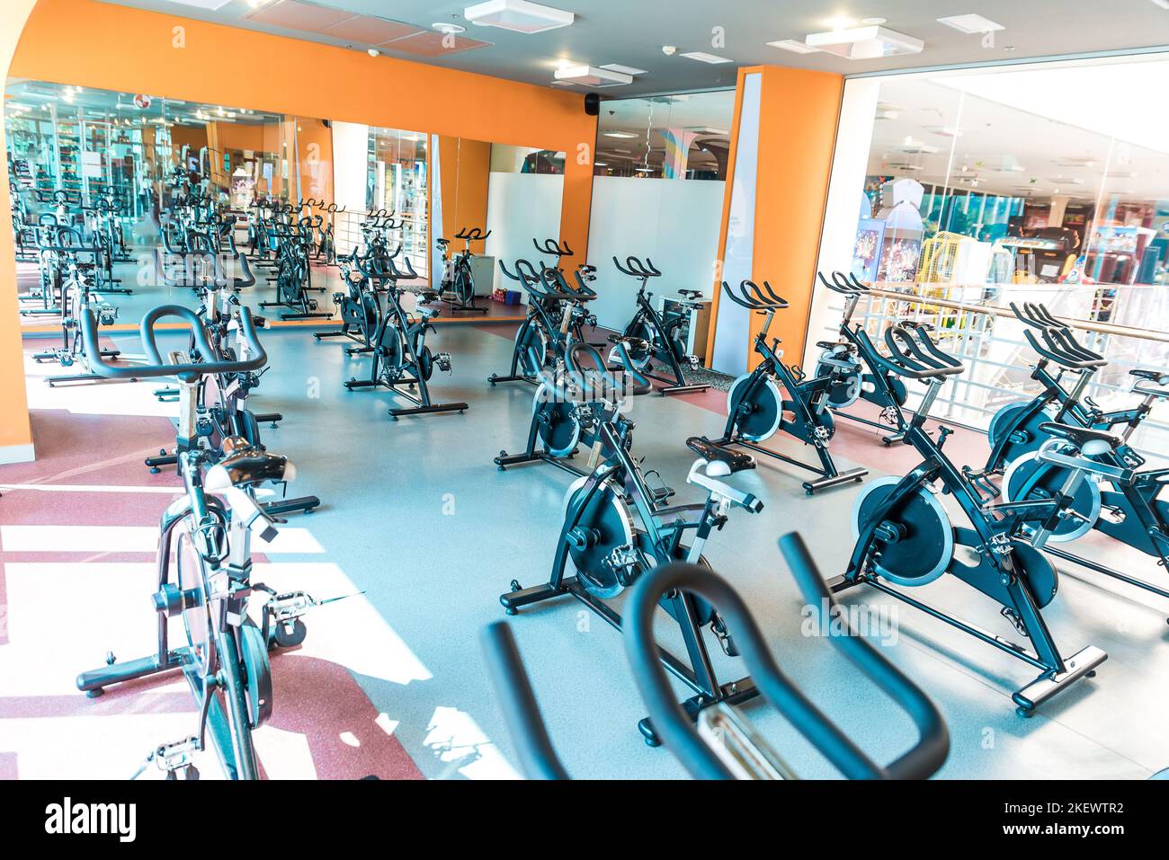 Modern gym interior with equipment. Row of training exercise bikes detail, backlight. Healthy lifestyle concept Stock Photo