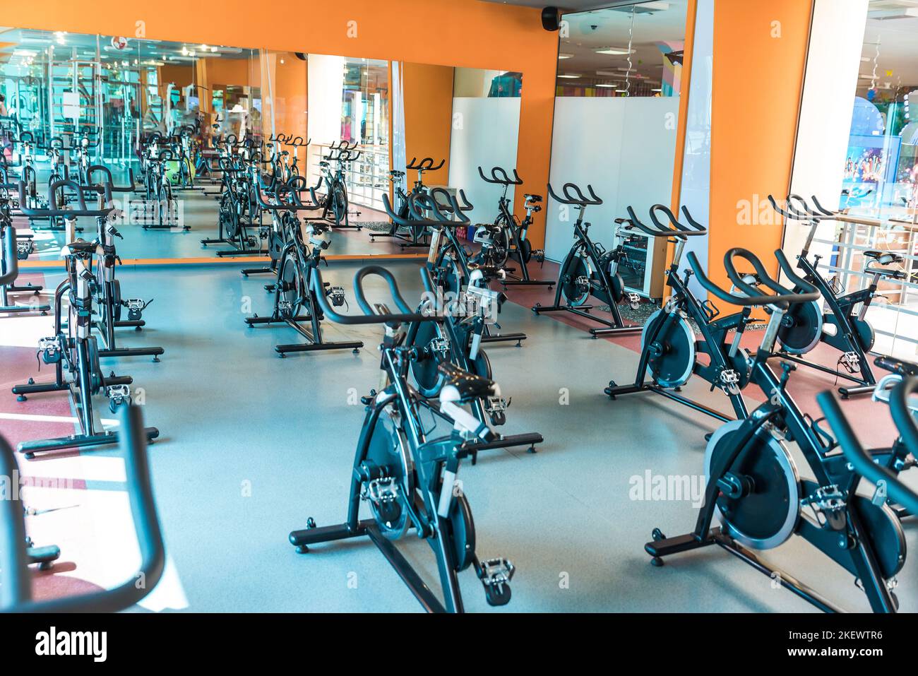 Modern gym interior with equipment. Row of training exercise bikes detail, backlight. Healthy lifestyle concept Stock Photo