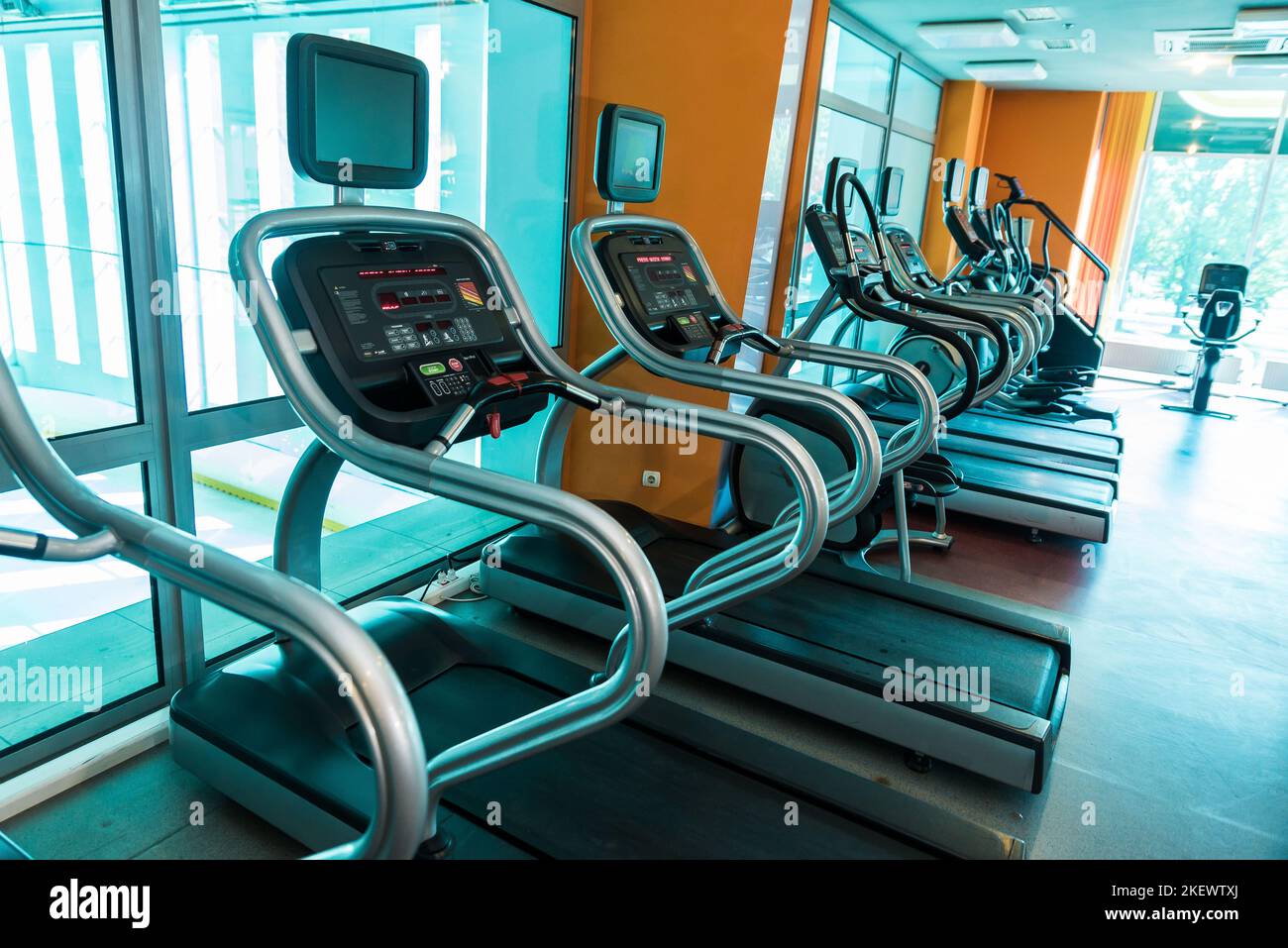 Interior of modern gym fitness room with large windows and treadmills ...