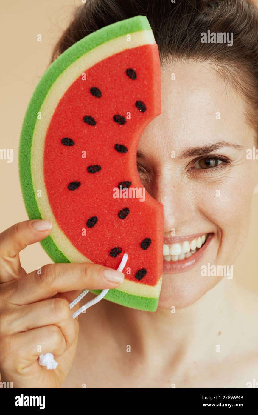 smiling 40 years old woman with watermelon shower sponge. Stock Photo