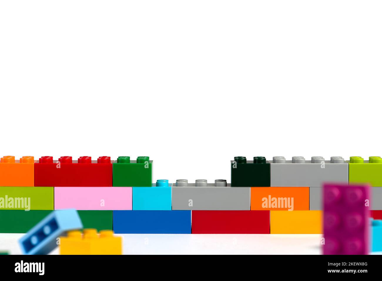 The child builds a tower of blocks. Toy building block in hand close-up. The concept of building and developing fine motor skills of hands Stock Photo