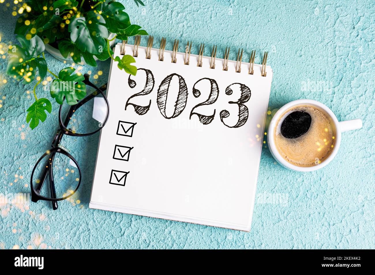 New year goals 2023 on desk. 2023 goals list with notebook, coffee cup, plant on blue table. Resolutions, plan, goals, action, checklist, idea concept Stock Photo