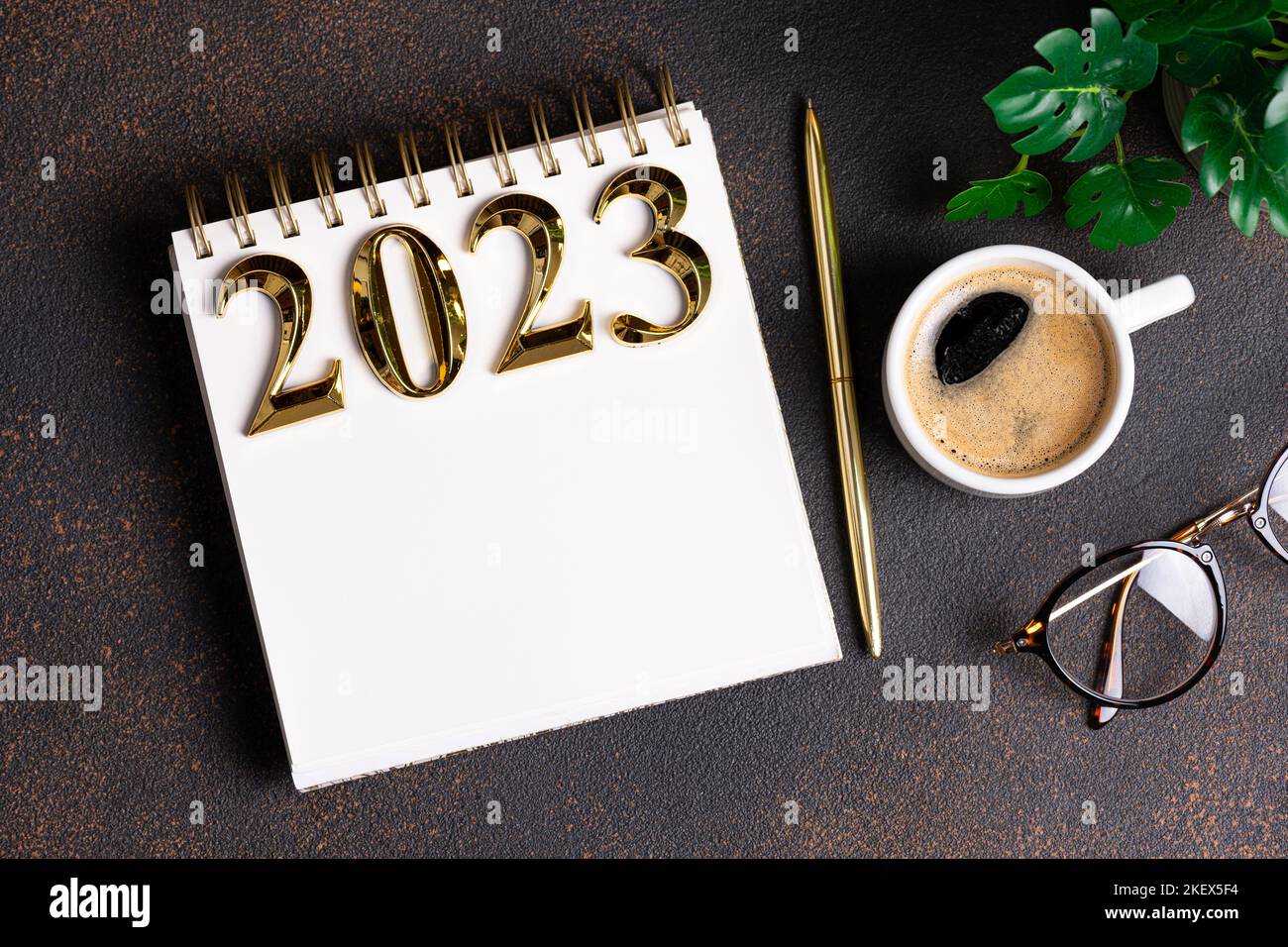 New year resolutions 2023 on desk. 2023 resolutions list with notebook, coffee cup on table. Goals, resolutions, plan, action, checklist concept. New Stock Photo
