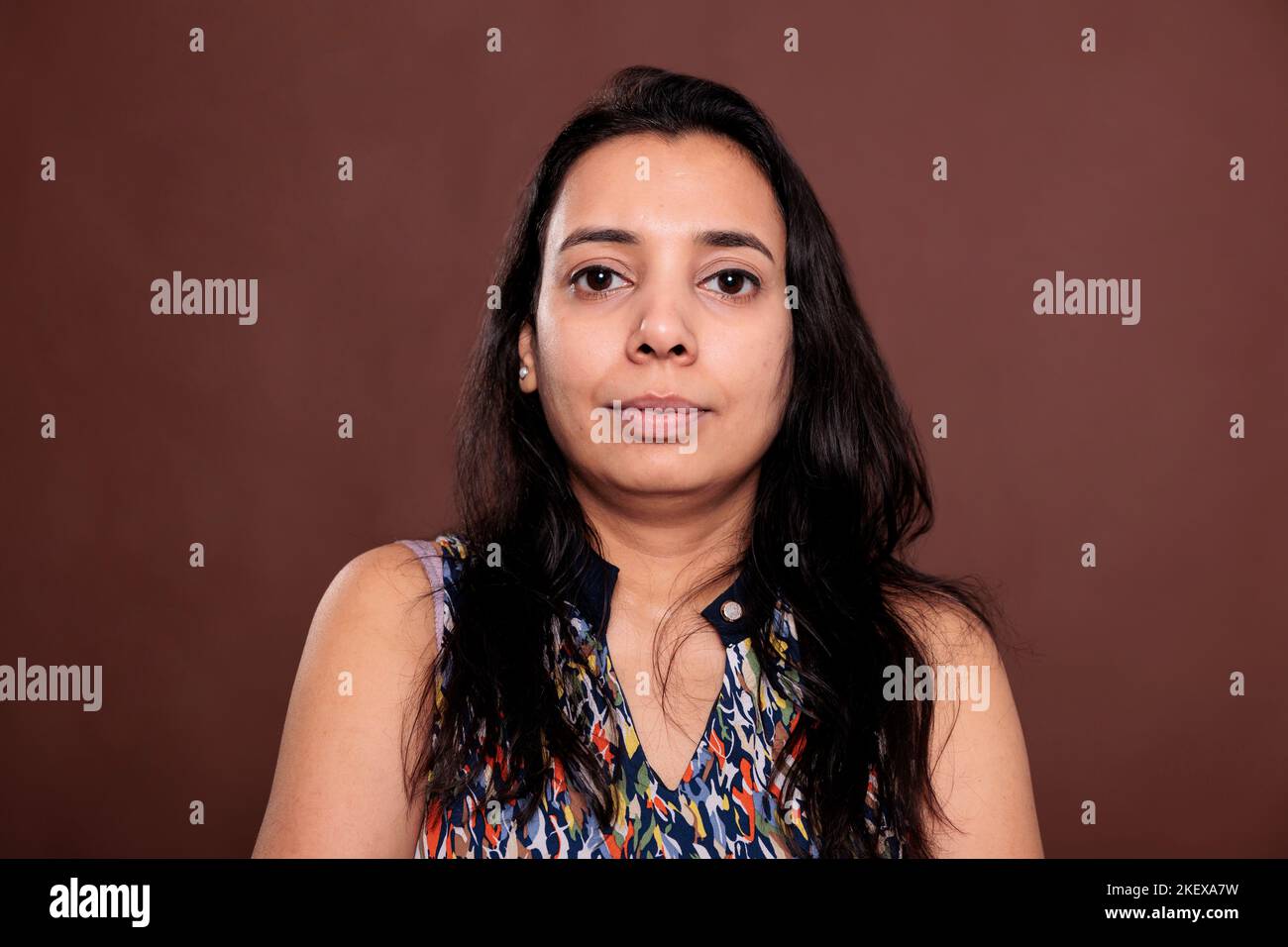 Indian woman looking at camera medium closeup portrait. Calm lady with