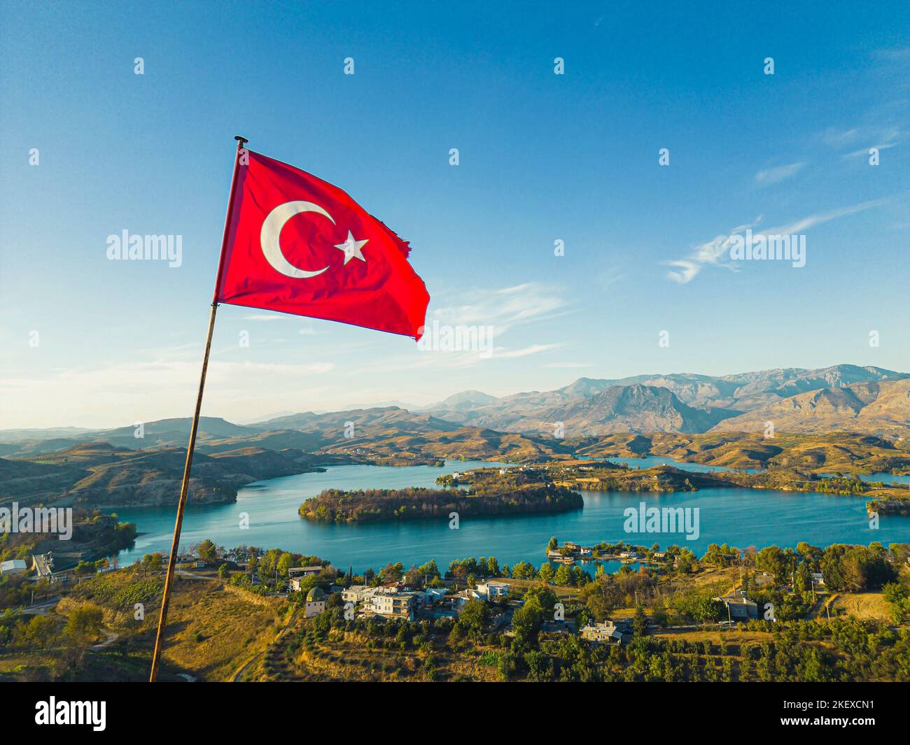 Turkish flag fluttering above picturesque Green Lake Manavgat. Lush green mountainous landscape with clear blue waer wand bright sky. Tourist destination. Horizontal shot. High quality photo Stock Photo