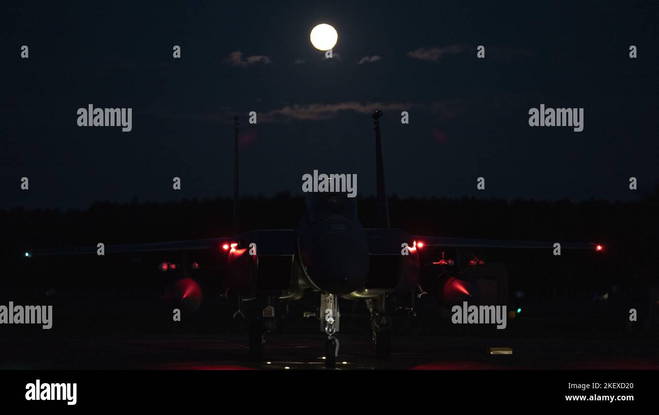 An F-15E Strike Eagle assigned to the 492nd Fighter Squadron awaits takeoff under a full moon at Royal Air Force Lakenheath, England, Nov. 11, 2022. The Liberty Wing conducts routine training operations to continue to deter foreign adversaries against the United States, its Allies, and partners. (U.S. Air Force photo by Staff Sgt. Gaspar Cortez) Stock Photo