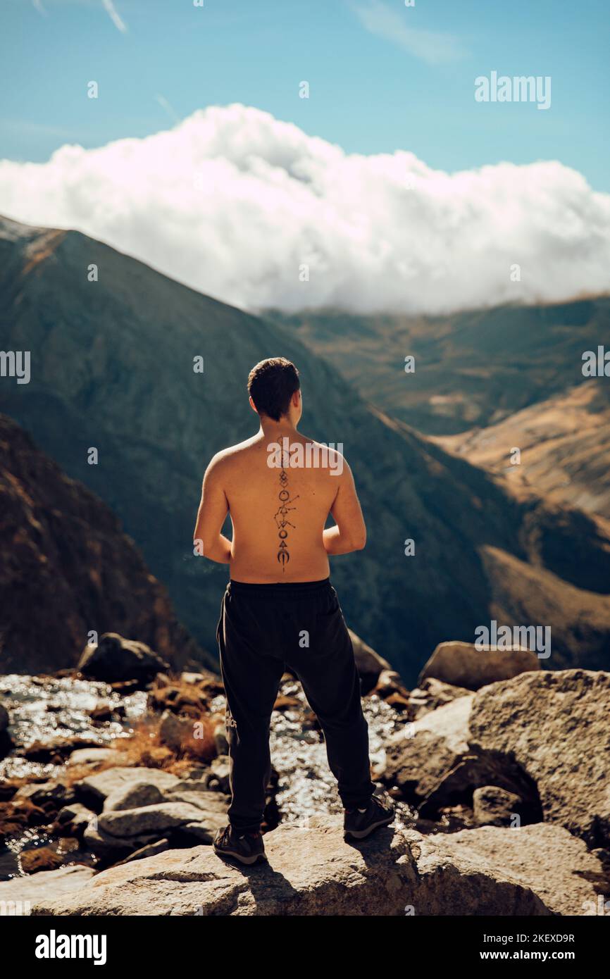 Boy looking at an impressive mountain landscape from the top Stock Photo