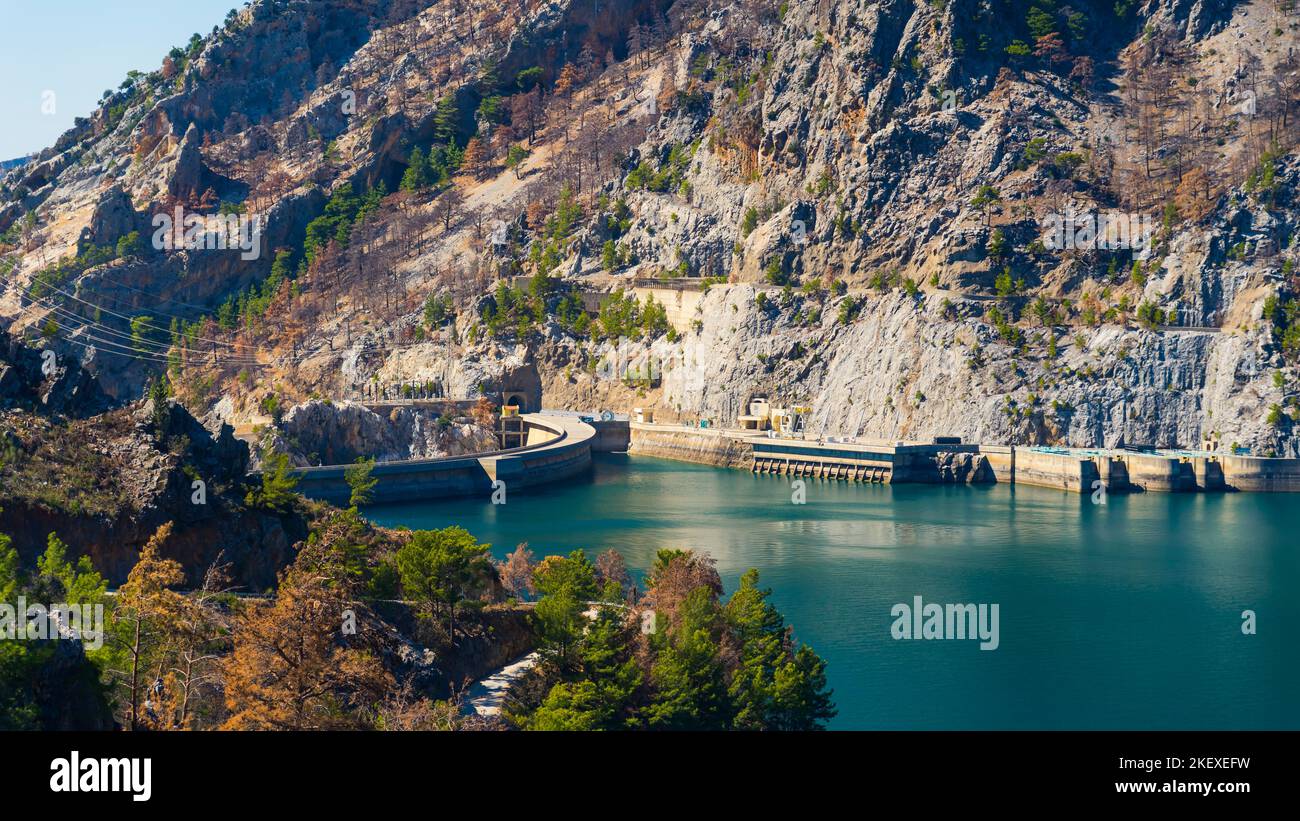 Scenic view of mountains surrounding Olympinar Lake Dam. Clear blue water lake and trees in the foreground. Horizontal outdoor shot. High quality photo Stock Photo