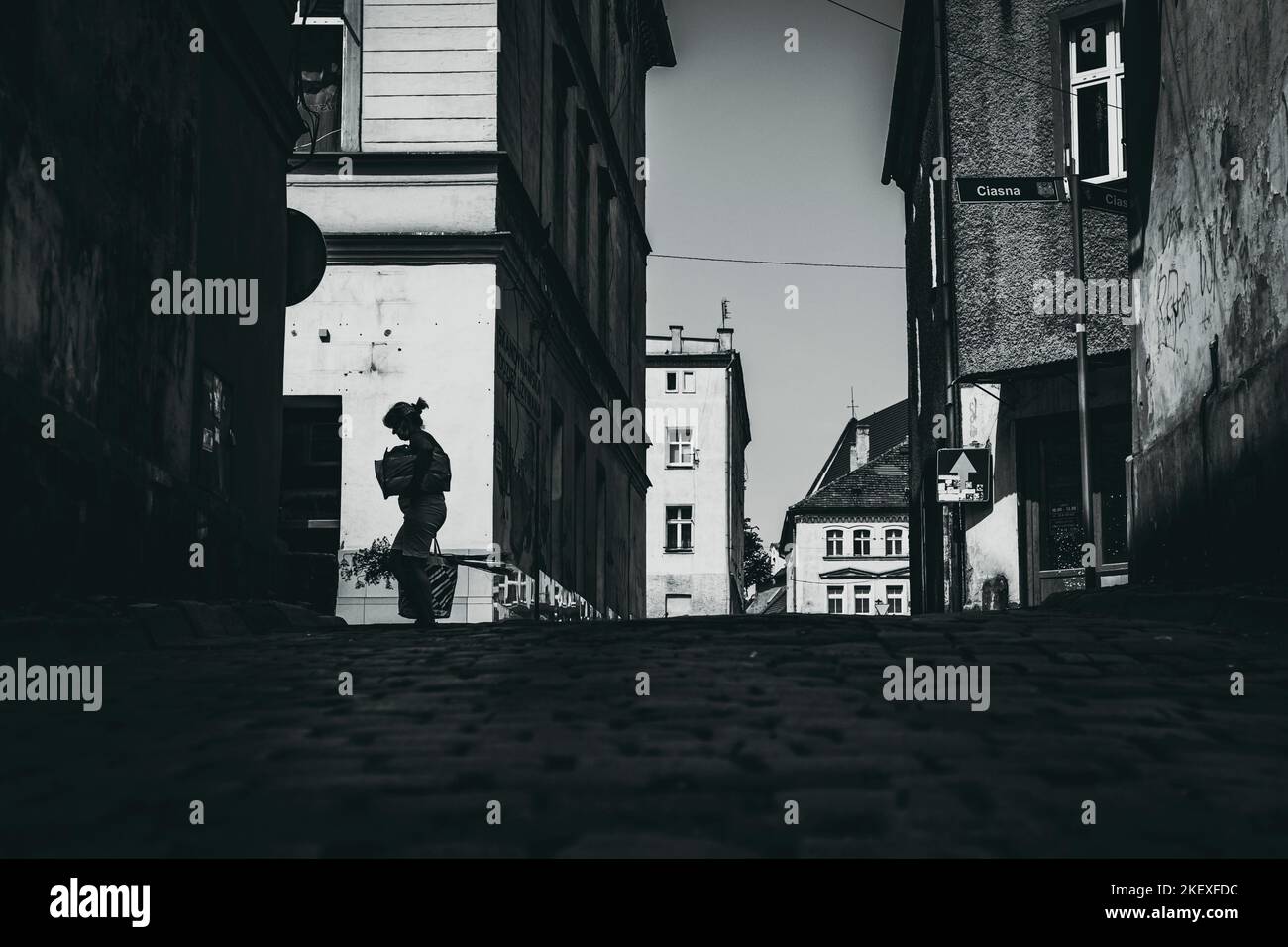 Woman walking on street alley hi-res stock photography and images - Alamy