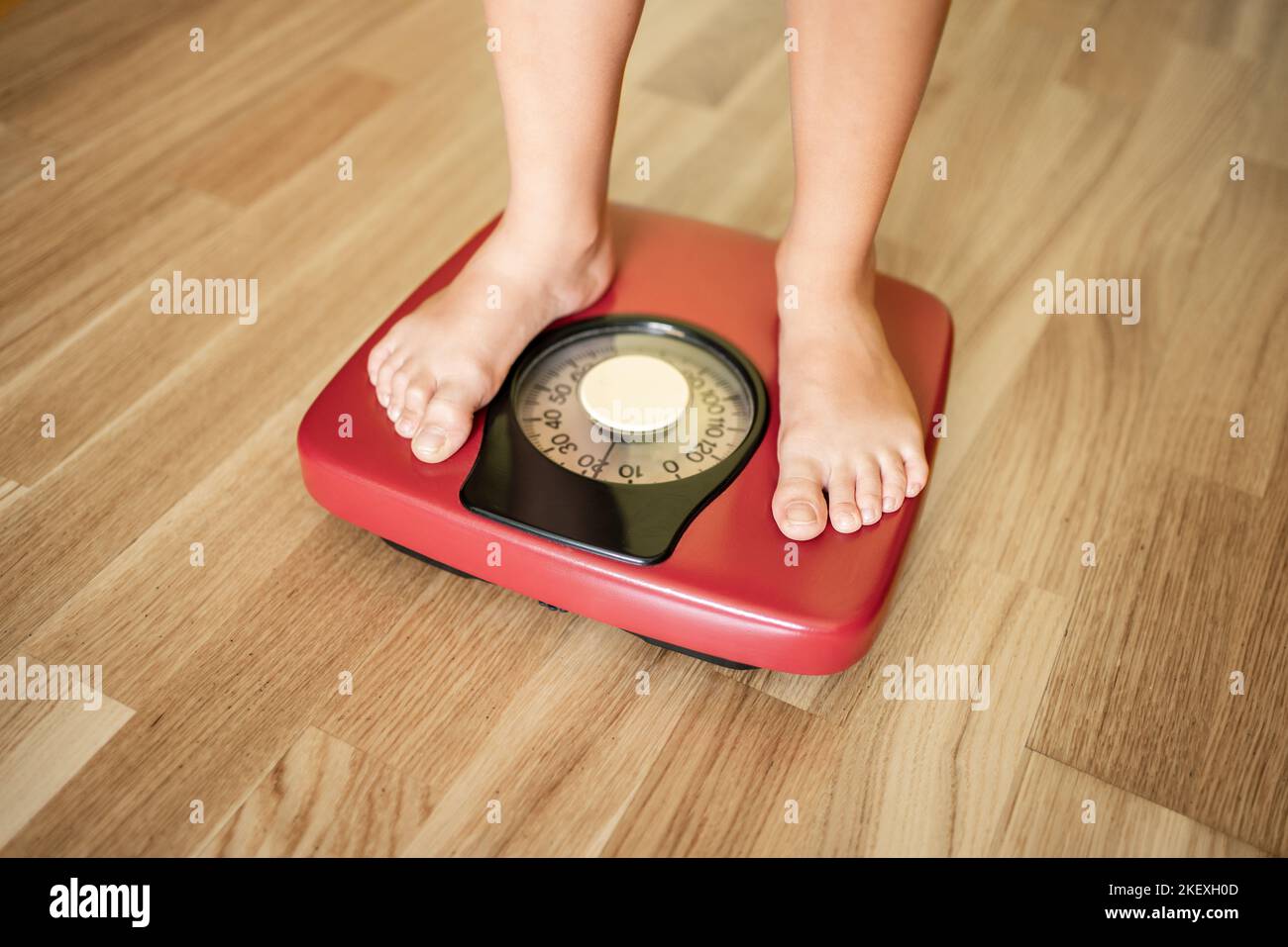 Close up of boy measures weight on a weight scale. Stock Photo