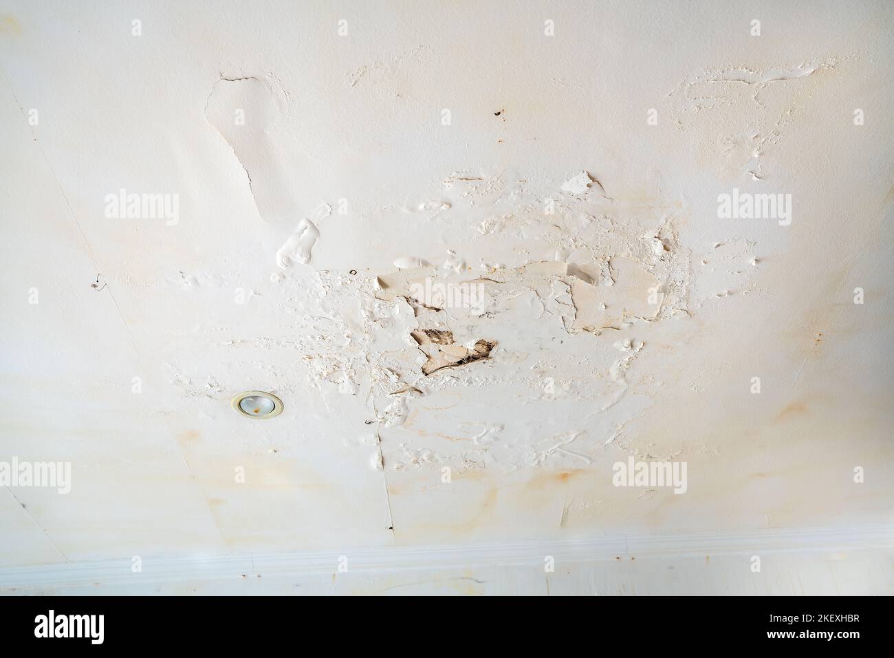 Rain water leaks on the wall causing damage and peeling paint next to