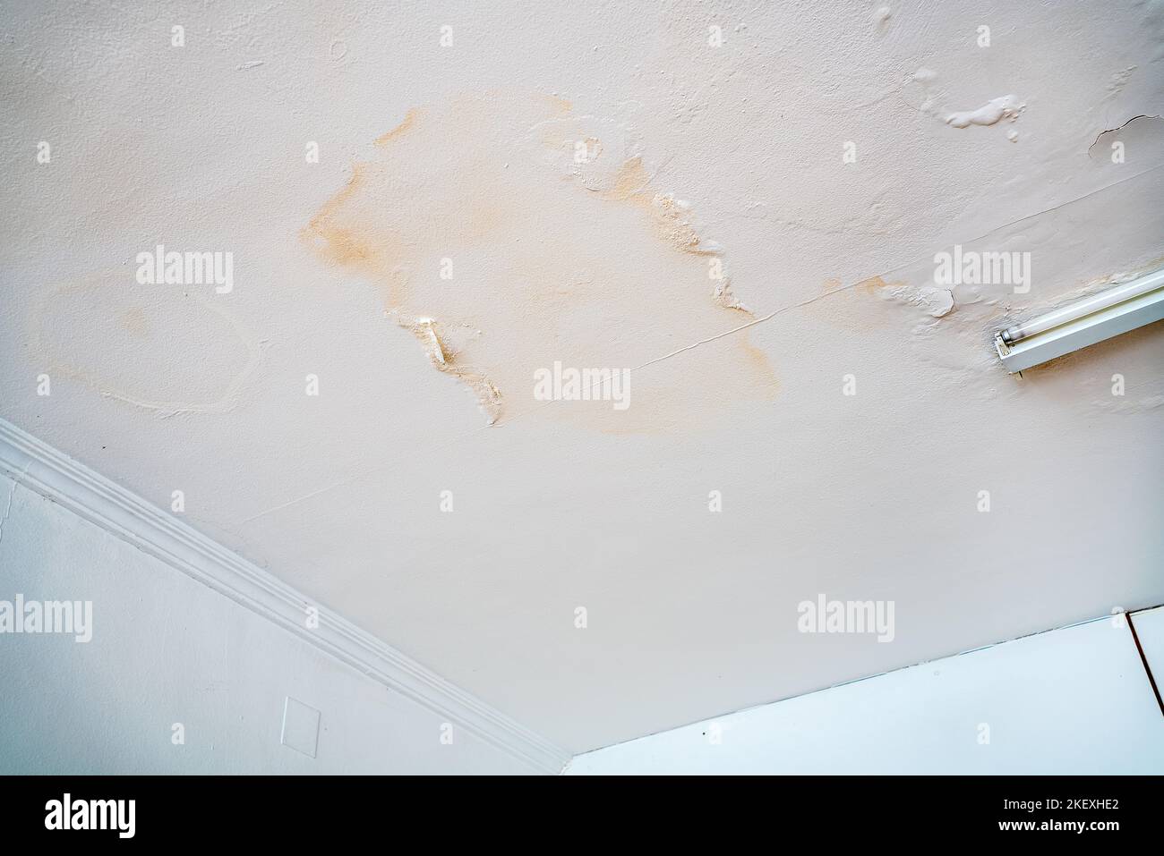 Rain water leaks on the wall causing damage and peeling paint next to