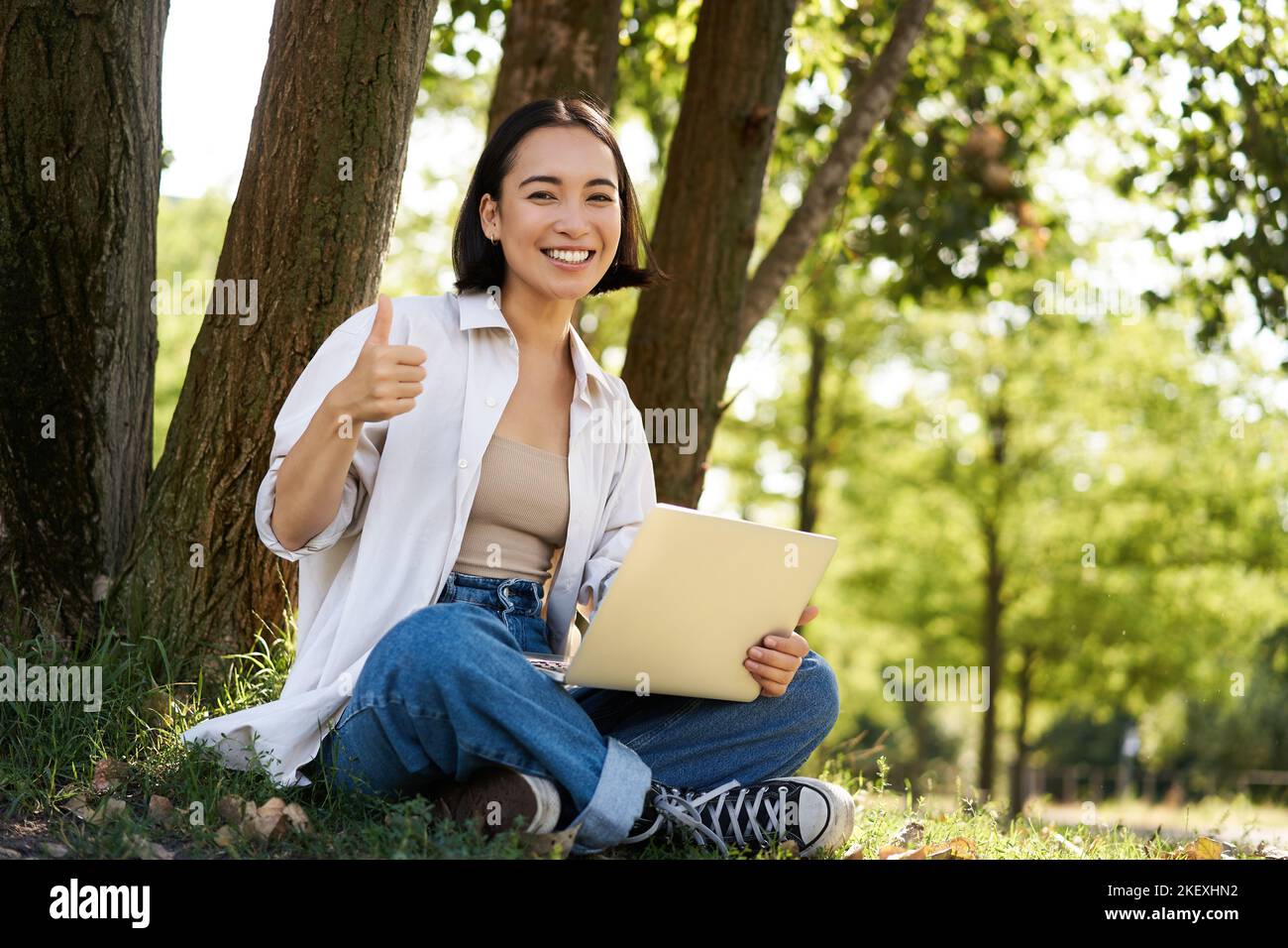 Portrait of asian young woman, student doing homework, working in park ...