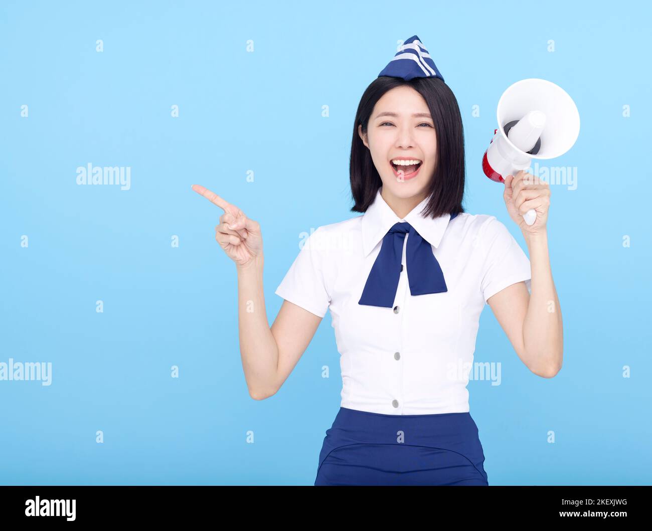 Airplane stewardess  woman shouting through the megaphone isolated on blue background Stock Photo