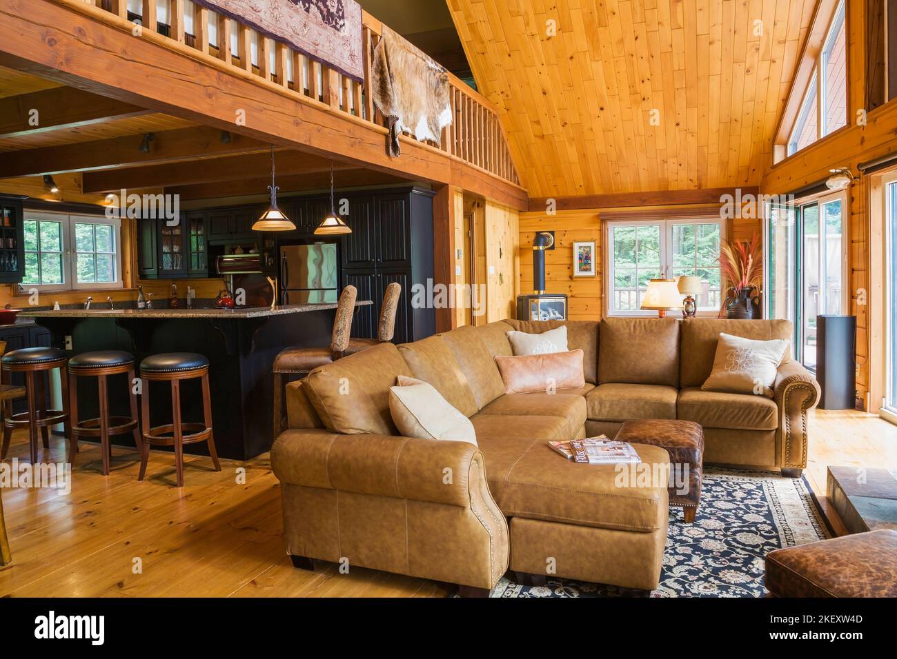 Tan leather sectional sofa in living room with view of kitchen and mezzanine inside a milled