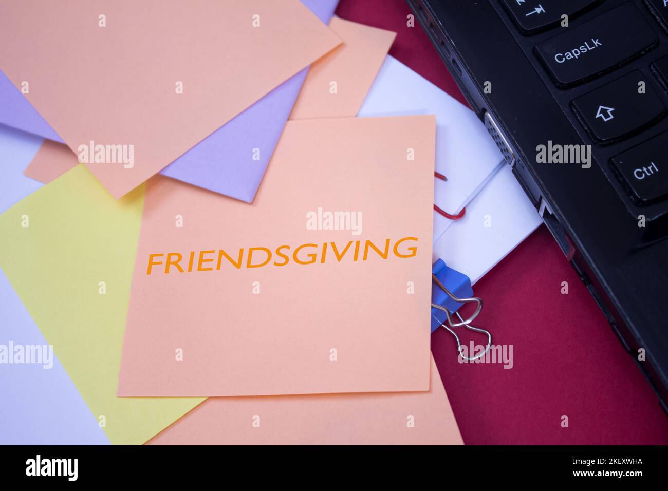 Friendsgiving. Text on adhesive note paper. Event, celebration reminder message. Stock Photo