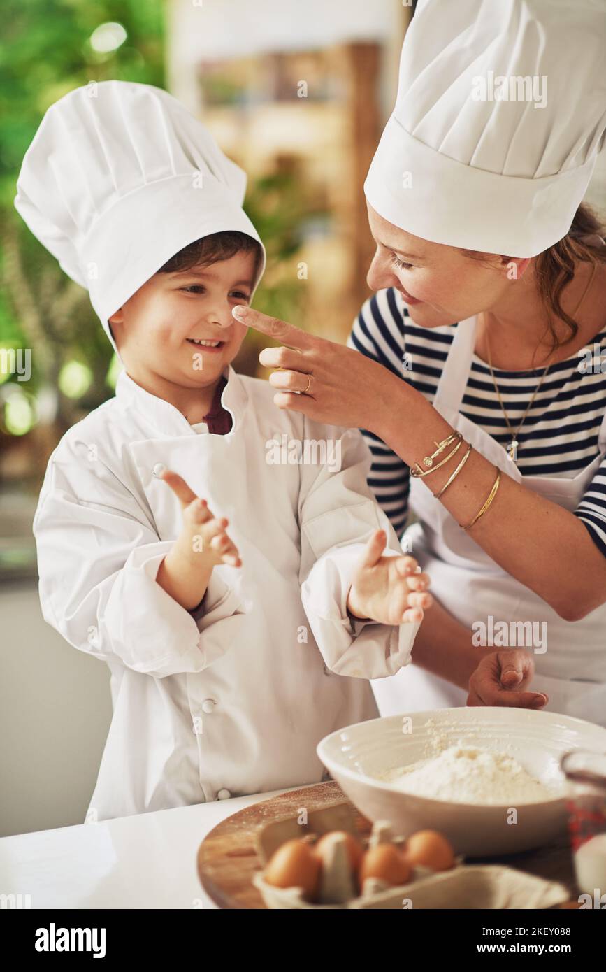 Youve got a bit on your nose. a mother and her young son baking together in the kitchen. Stock Photo