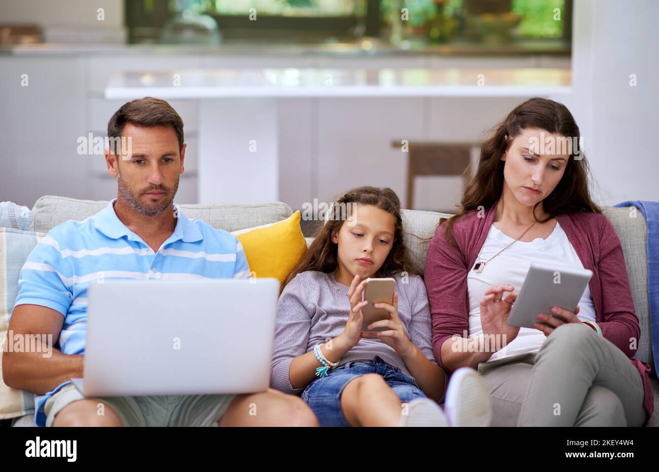 Connecting as a family. a family sitting on the sofa and using their ...