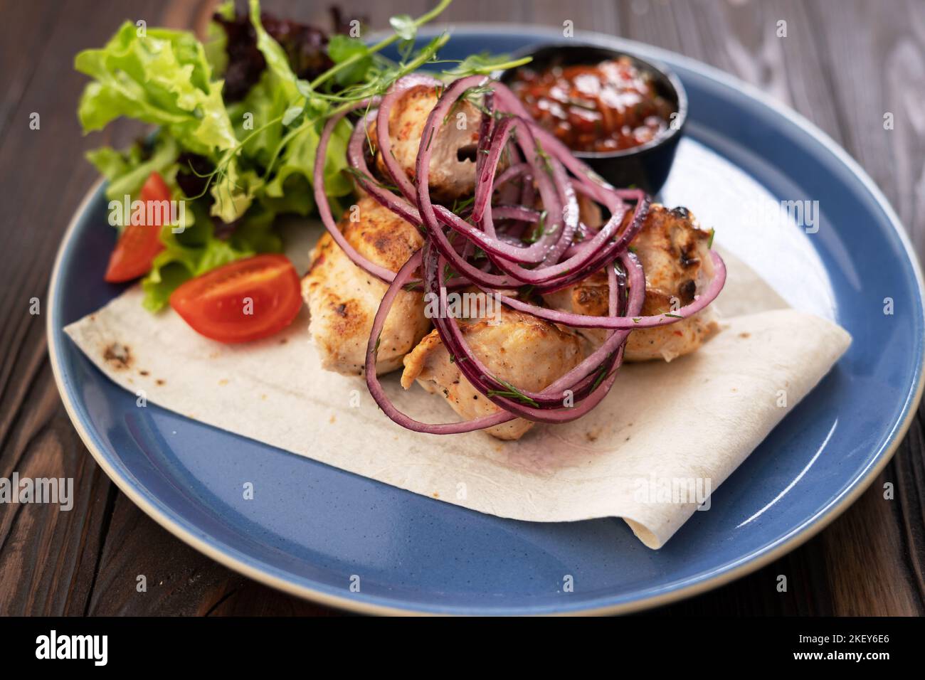 Kebabs - grilled meat, kebab with vegetables on blue plate. Bbq restaurant menu. Stock Photo