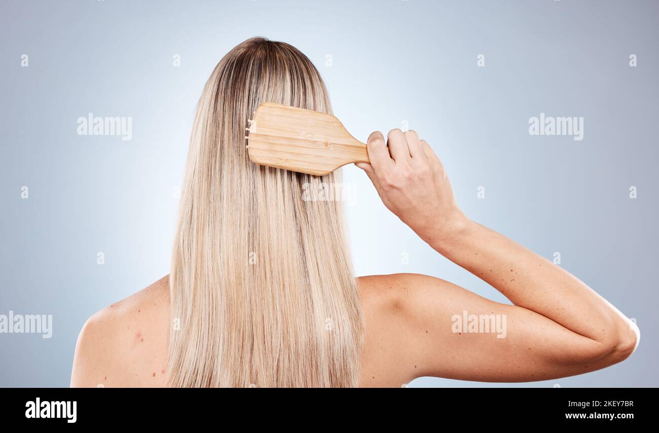 Hair care, beauty brush and back of woman in studio isolated on gray background. Hair style, grooming and female model brushing hair for healthy Stock Photo