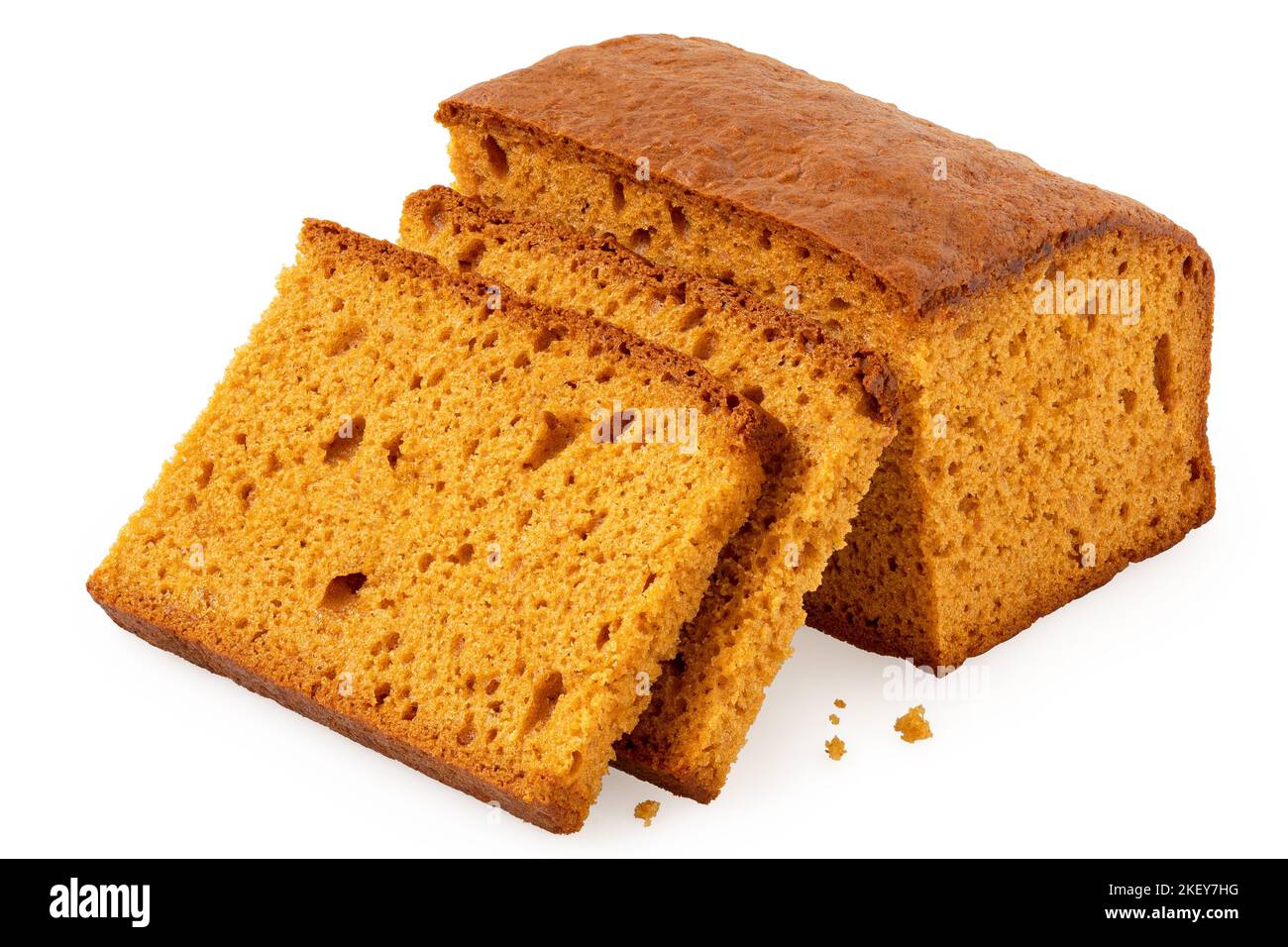 Two slices of spiced honey cake next to a loaf of honey cake isolated on white. Stock Photo