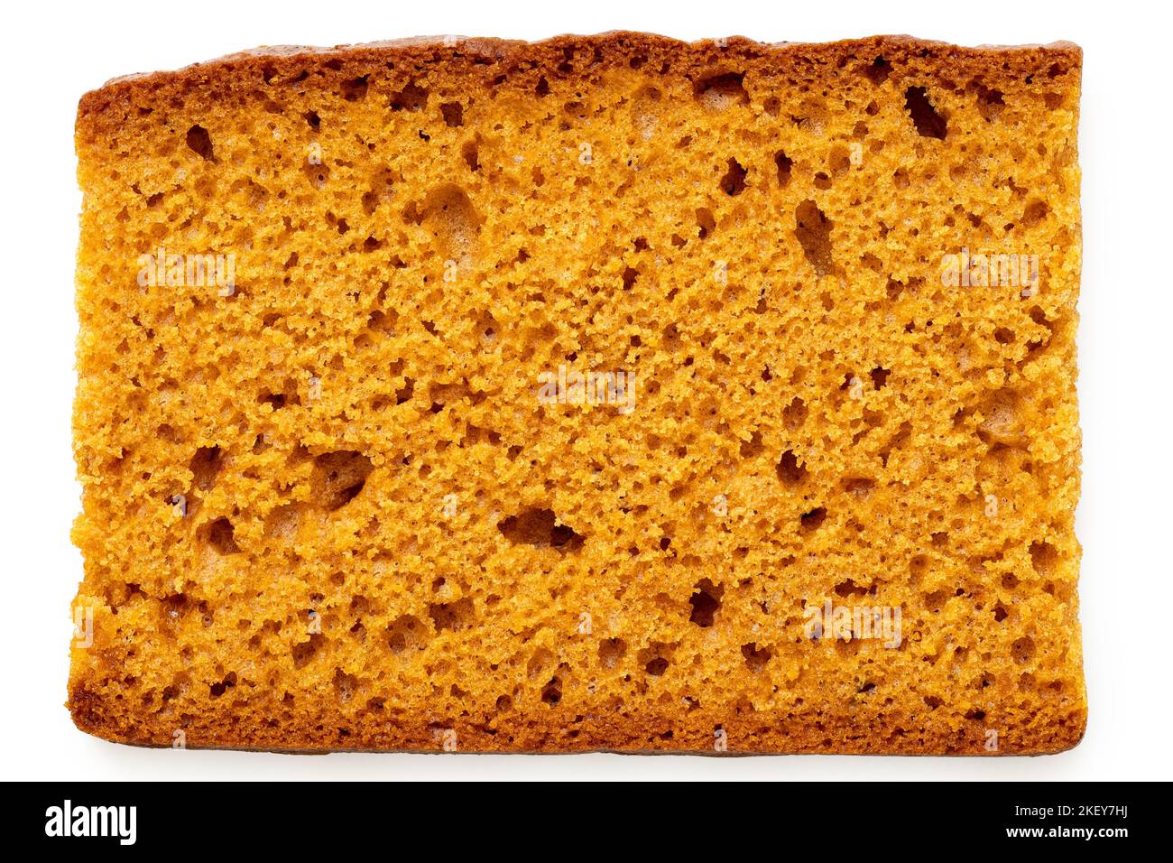Slice of spiced honey cake isolated on white. Top view. Stock Photo