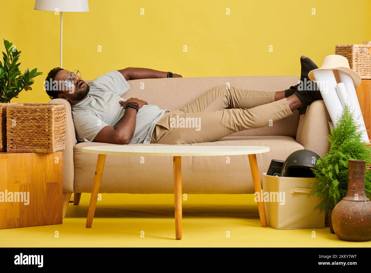 Tired man fell asleep on sofa after dinner Stock Photo