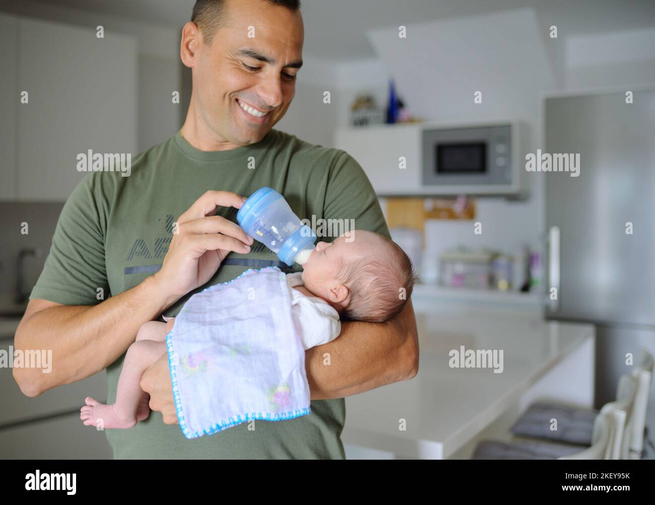 Happy father feeding newborn baby Stock Photo