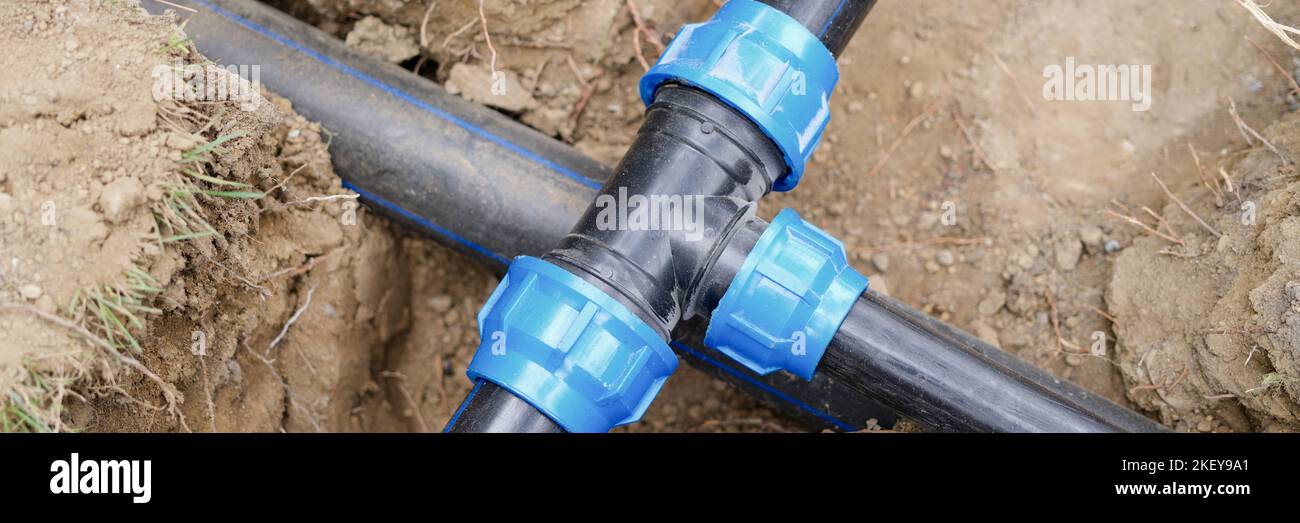 Installed PVC water pipes in trench at construction site Stock Photo