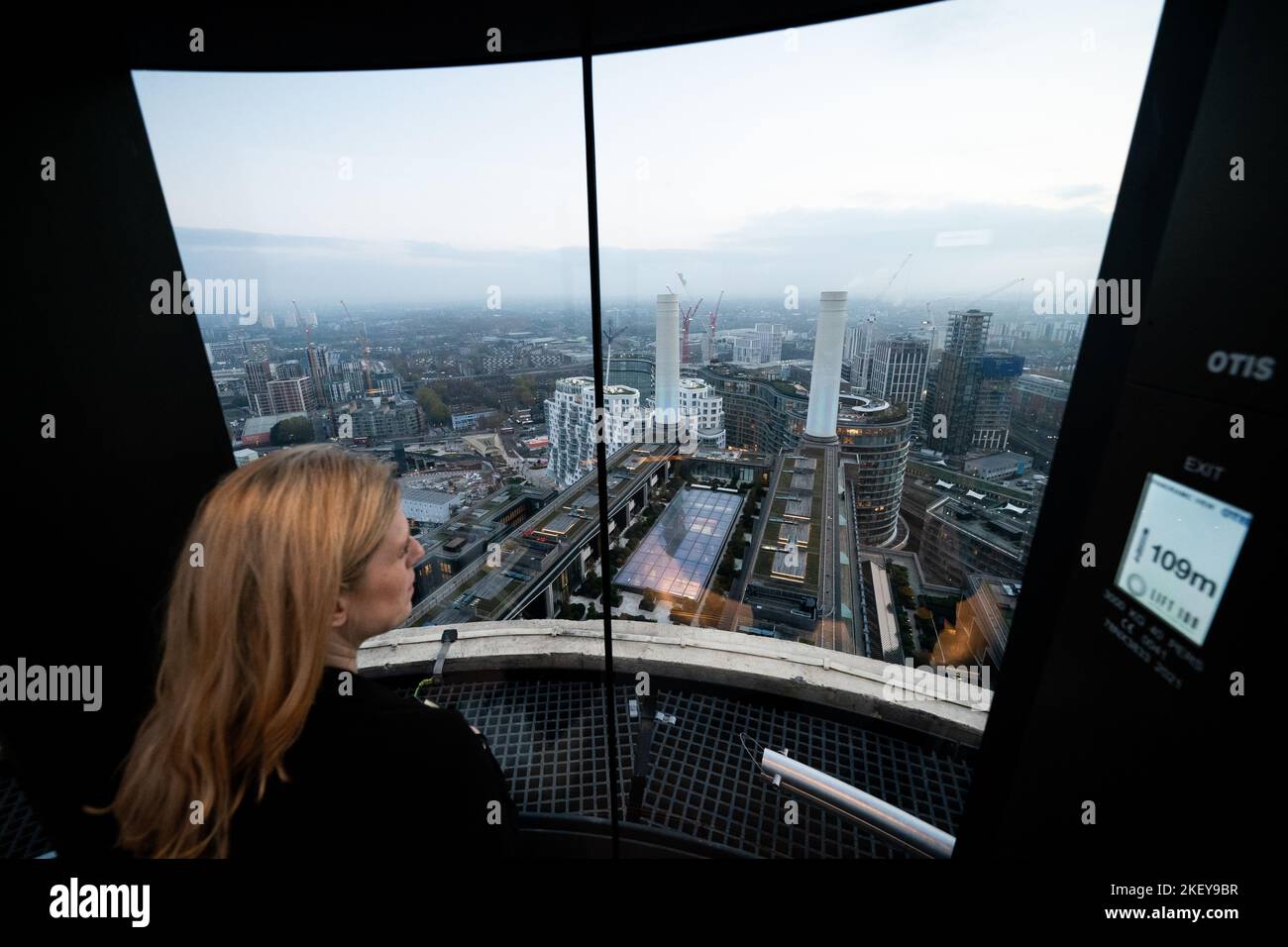 A person looks out over Battersea Power station from Lift 109 at Battersea Power Station, combining an exhibition space, housed in the former power station's art deco turbine hall A, with a glass elevator ascent to the top of the Grade II listed building's north-west chimney, reaching a viewpoint 109 metres above ground. Picture date: Monday November 14, 2022. Stock Photo