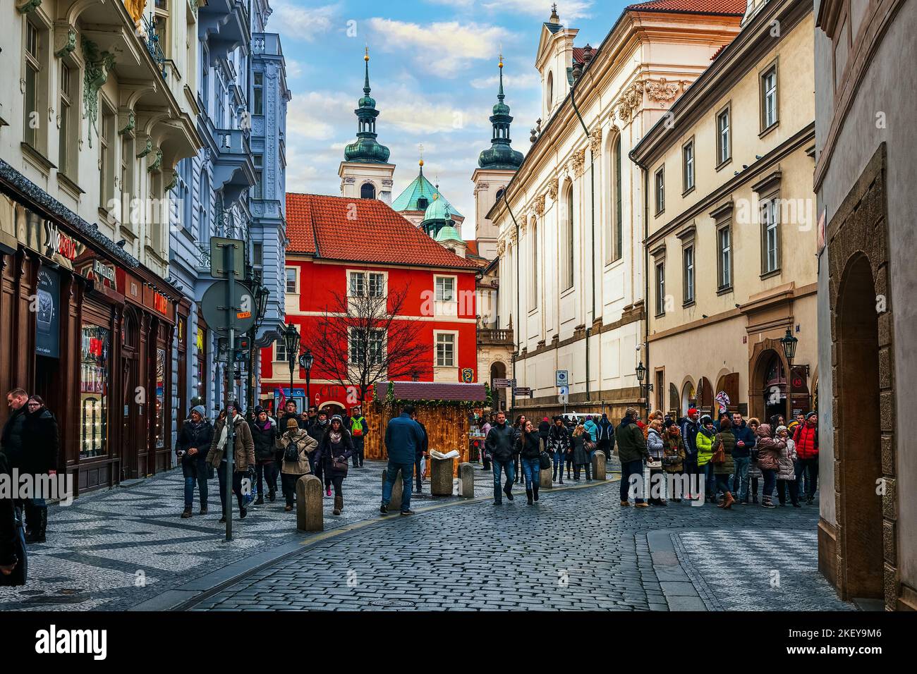 People on narrow cobblestone street among historic buildings in Old Town of Prague - capital of Czechia. Stock Photo