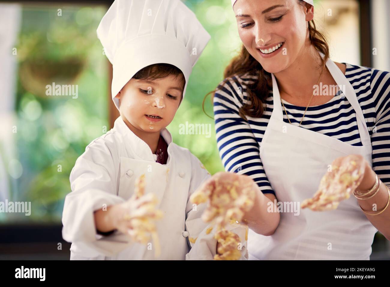 Good things come to those who bake. a mother and her son playing with cookie dough in the kitchen. Stock Photo