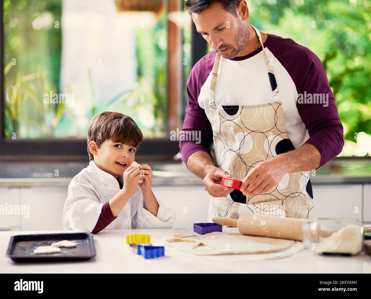 Im the boss of this dough. a father and son baking biscuits in the kitchen. Stock Photo
