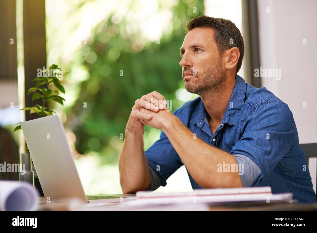 Feeling confident about his small business. a man looking thoughtful while working from home. Stock Photo