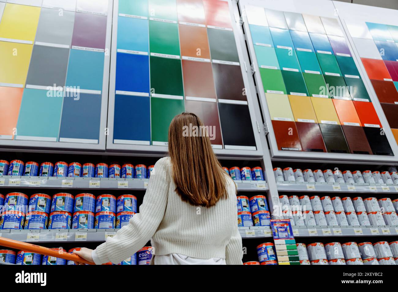 Woman in front of samples of facade and interior paint color palette on
