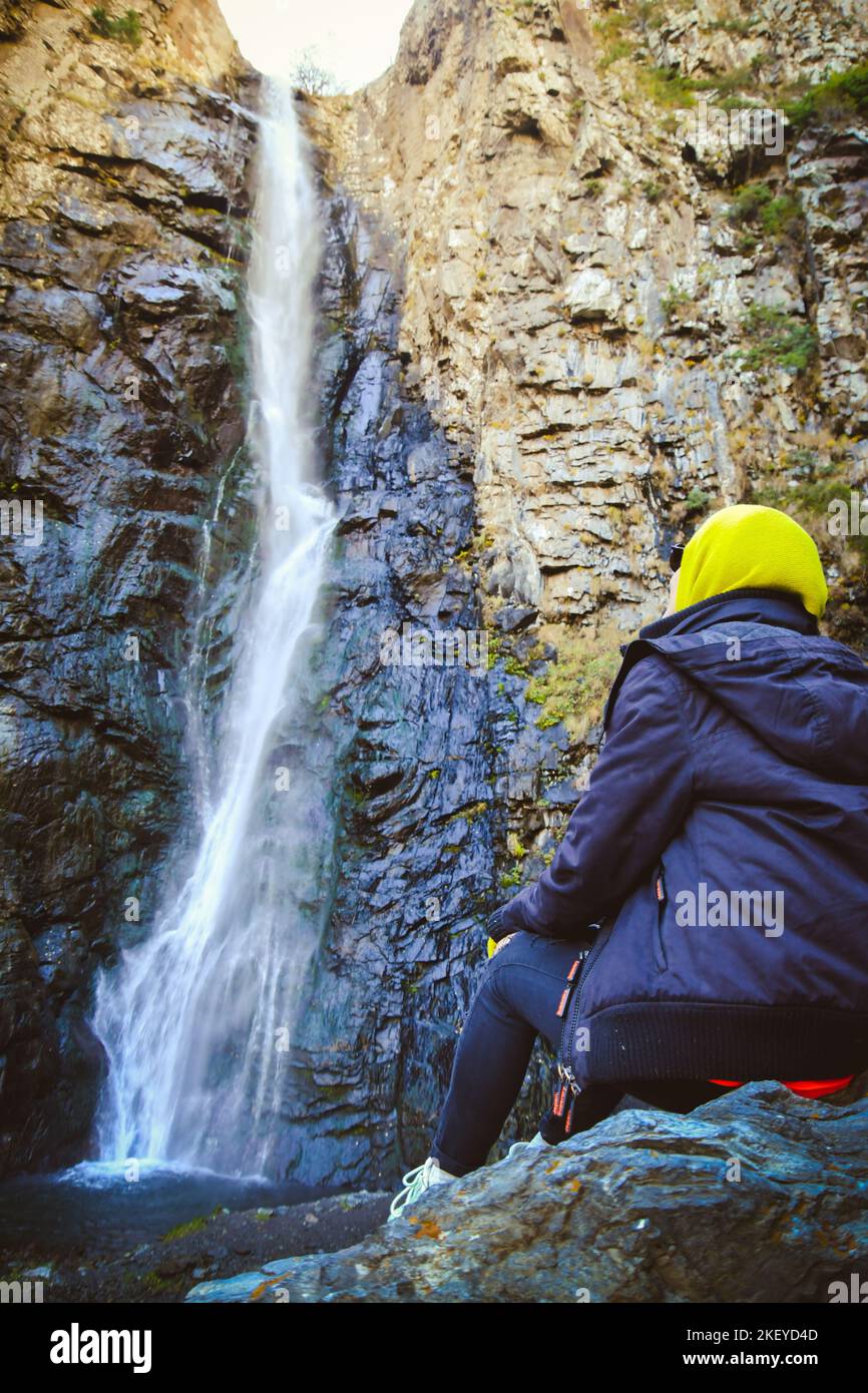 Tourist by Gveleti waterfall Falls, near the town of Stepantsminda, in the Caucasus Mountains, North Georgia Stock Photo