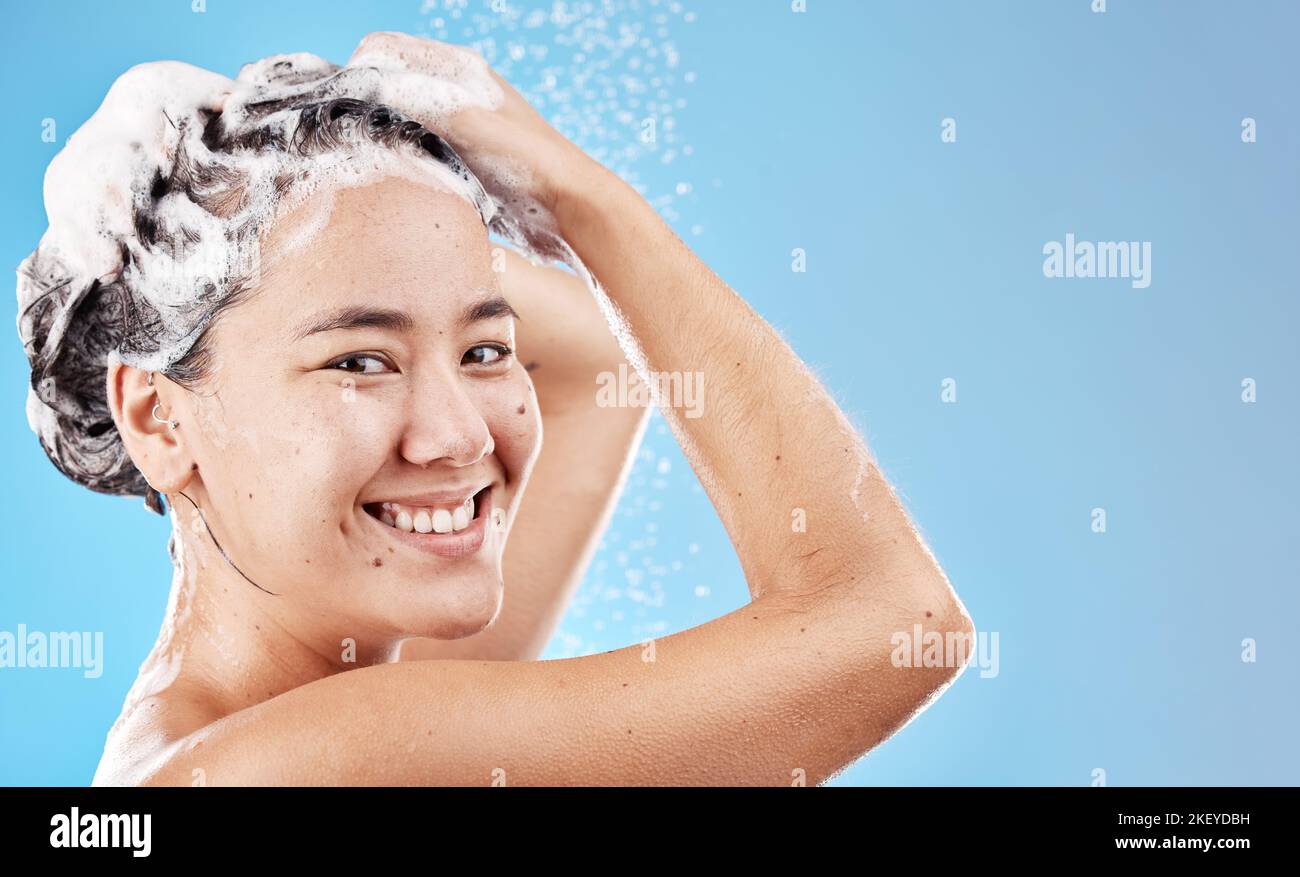 Water, shampoo and woman in shower on blue background, haircare and