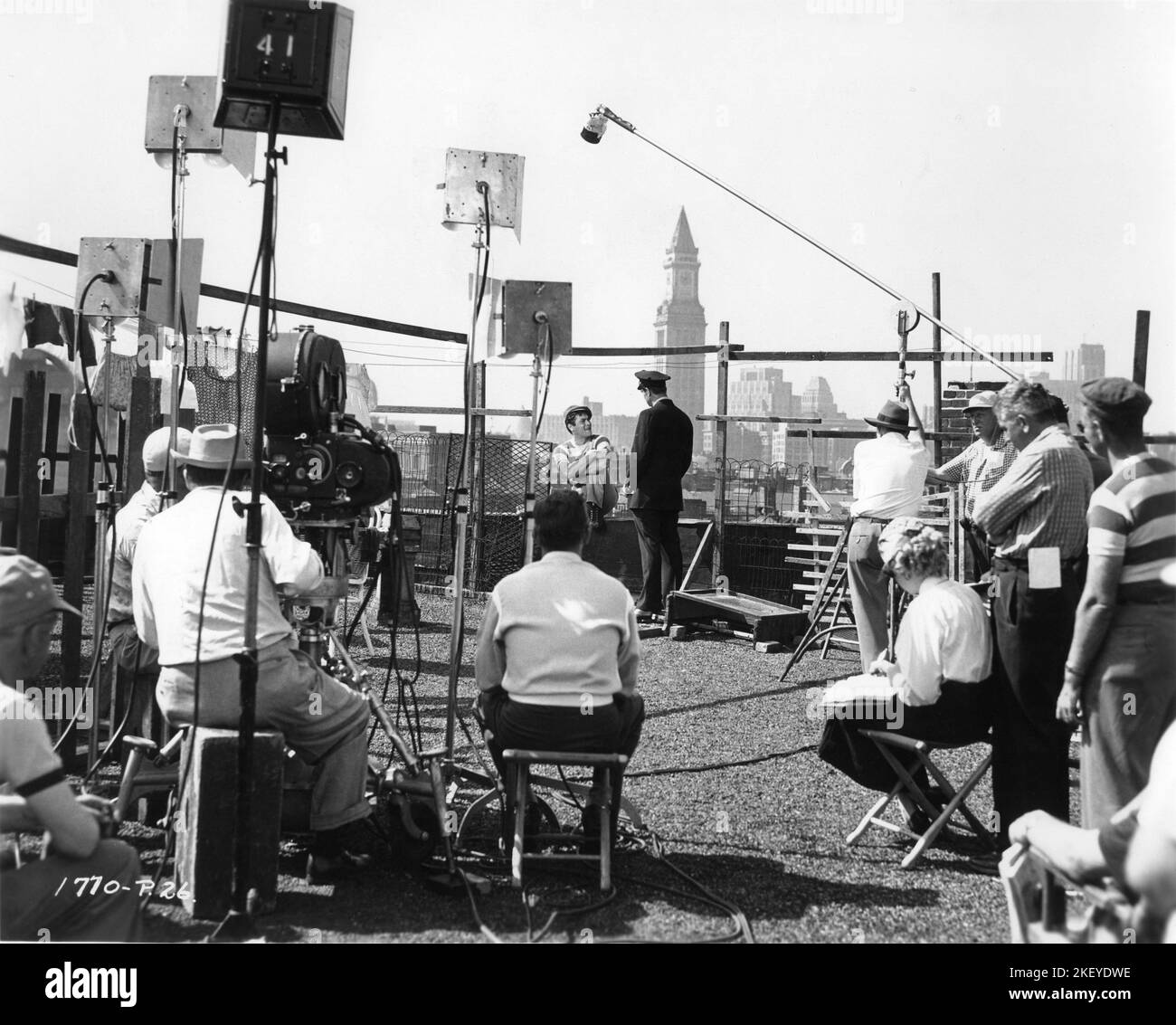 TONY CURTIS and GEORGE NADER on set location candid in Boston with Movie / Camera Crew during filming of SIX BRIDGES TO CROSS 1955 director JOSEPH PEVNEY cinematographer William H. Daniels producer Aaron Rosenberg Universal International Pictures (UI) Stock Photo