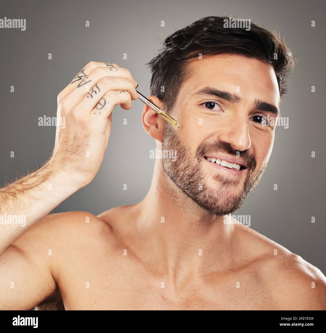 Skincare, health and portrait of man with serum on face for anti aging and glowing skin on studio background. Beauty, facial and male model with Stock Photo