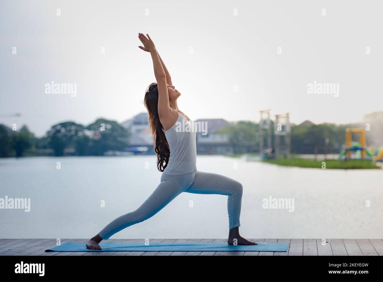 Young Asian healthy woman doing yoga in the park at lake pier Stock ...