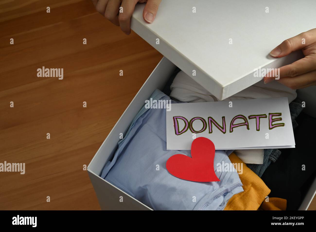 Woman preparing donate box for giving or charity activity. Donation